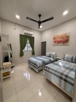 a bedroom with two beds and a painting on the wall at Lodging Mak Endon in Seri Manjung