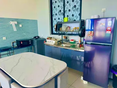 a kitchen with a purple refrigerator and a counter at cozy 3BR family suites 10pax in Jelutong