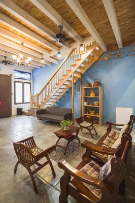 a living room with a staircase and wooden furniture at My Guesthouse 109 - SELF CHECK IN in George Town