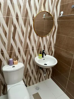 a bathroom with a toilet and a mirror and a sink at Pitaloka The Lakes Homestay in Batu Gajah