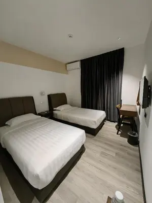 a hotel room with two beds and a television at Galaxy Hotel Bandar Perda in Bukit Mertajam