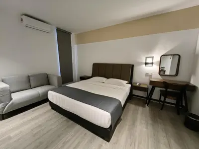a bedroom with a bed and a couch at Galaxy Hotel Bandar Perda in Bukit Mertajam