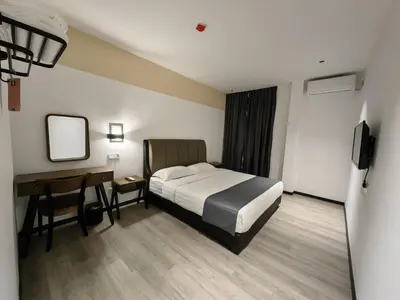 a hotel room with a bed and a desk at Galaxy Hotel Bandar Perda in Bukit Mertajam