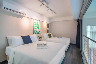 a hotel room with two beds and a couch at Maritime Suites by Stellar ALV in Jelutong