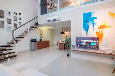 a large living room with a staircase and a tv at Maritime Suites by Stellar ALV in Jelutong