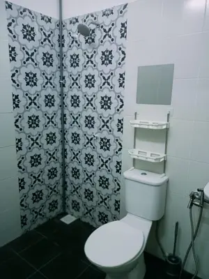 a bathroom with a toilet and a black and white wallpaper at Double H Homestay in Tanjung Rambutan