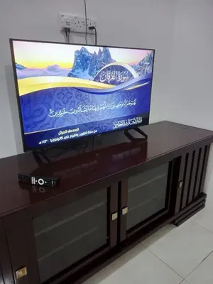a flat screen tv sitting on top of a entertainment center at Double H Homestay in Tanjung Rambutan