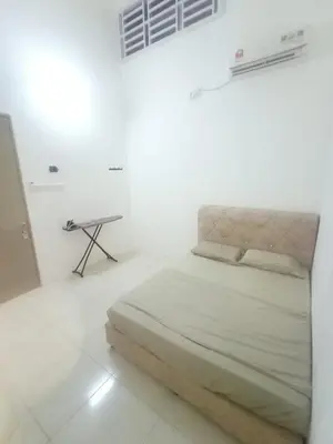a bed in a white room with a table at Double H Homestay in Tanjung Rambutan
