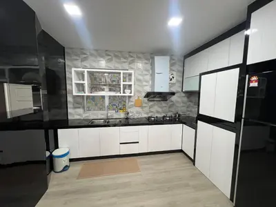 a kitchen with white cabinets and a black counter top at DanteQuintet Cameron Highlands in Tanah Rata