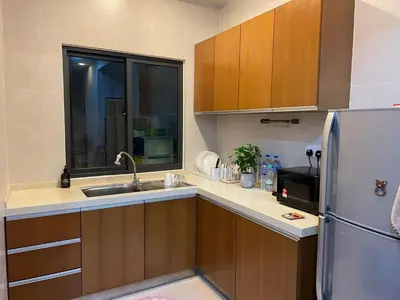 a kitchen with wooden cabinets and a stainless steel refrigerator at GreenValley in Brinchang