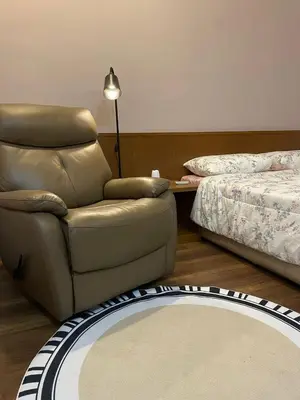 a living room with a chair and a bed at GreenValley in Brinchang