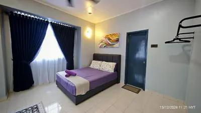 a bedroom with a bed with purple sheets and a window at Homestay Santai Bertam in Kepala Batas
