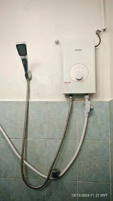 a shower with a hose hooked up to a wall at Homestay Santai Bertam in Kepala Batas