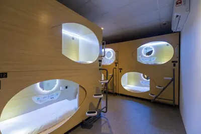 a hospital room with two beds and two mirrors at Resthub in George Town