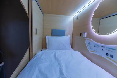 a small bed in a small room with a mirror at Resthub in George Town
