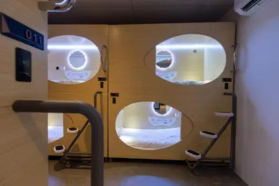 a hospital room with three circular windows and a bed at Resthub in George Town