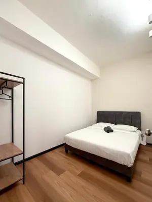 a white bedroom with a bed and a mirror at Sofu Inn in Jelutong