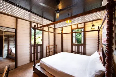 a bedroom with a bed in a room with wooden walls at Bagas Zakariah Orchard Lodge in Gopeng