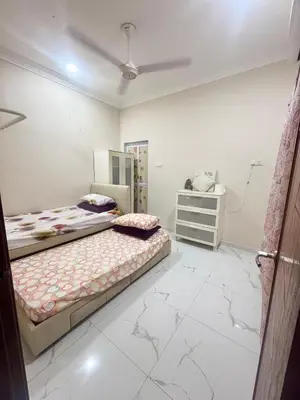 a bedroom with two beds and a dresser at Hannah Homestay Ipoh in Ipoh