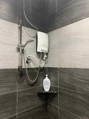 a shower with a soap dispenser in a bathroom at Rimbunan Padi Roomstay in Bagan Serai