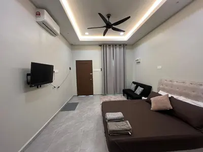a living room with a bed and a ceiling fan at Rimbunan Padi Roomstay in Bagan Serai