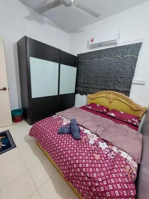 a bedroom with a bed with a red comforter at Alle Vacation Homes Tambun Ipoh in Ipoh