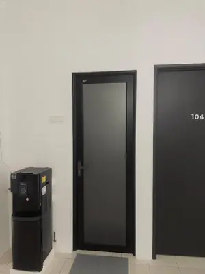 two black doors in a room next to a trash can at 39 Haus in Bukit Mertajam