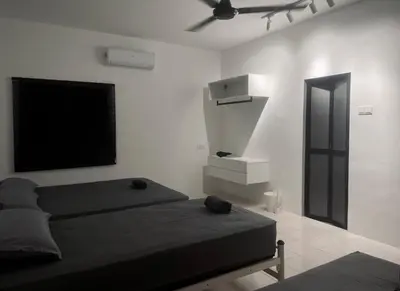 a bedroom with a bed and a flat screen tv at 39 Haus in Bukit Mertajam