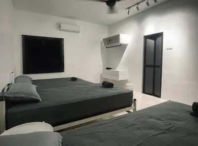 a bedroom with two beds and a television in it at 39 Haus in Bukit Mertajam