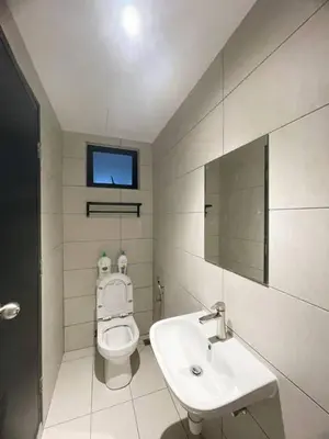 a bathroom with a toilet and a sink and a mirror at Jovial MarcResidence ````BmSongBanKheng in Bukit Mertajam