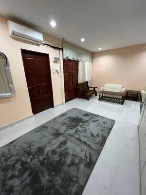 a living room with a door and a rug at Impiana Homestay in Kampong Kawak