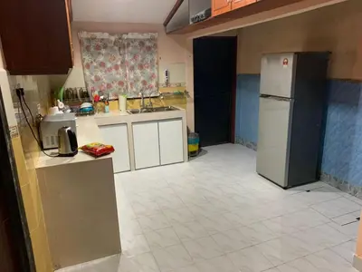 a kitchen with a refrigerator and a tile floor at Impiana Homestay in Kampong Kawak