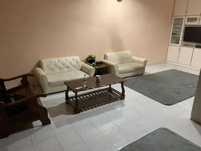a living room with two chairs and a coffee table at Impiana Homestay in Kampong Kawak