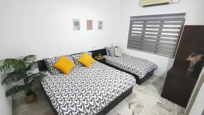 a bedroom with a bed and a couch with yellow pillows at 33 HOMESTAY 4 Room 5 MINUTE TO LEANING TOWER in Teluk Intan