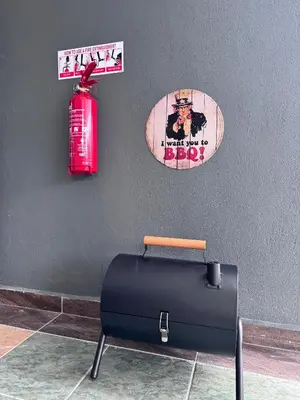 a suitcase and a fire extinguisher on a wall at Moon22 Private Pool in Ipoh
