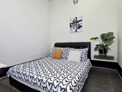 a bedroom with a black and white bed with pillows at 1813 HOME STAY 8 Roon 6 Bath 5MINUTE TO LEANING TOWER in Teluk Intan