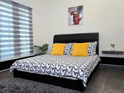 a bedroom with a bed with yellow and black pillows at 1813 HOME STAY 8 Roon 6 Bath 5MINUTE TO LEANING TOWER in Teluk Intan