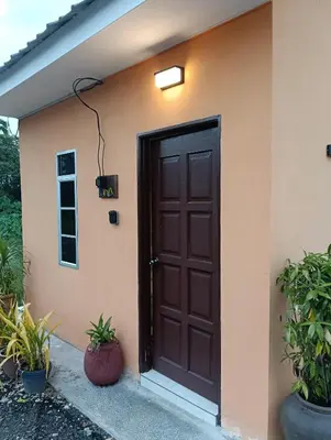 a brown door on a house with plants at D'Permata Roomstay Kampung Pelet in Kubang Semang