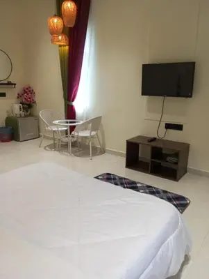 a bedroom with a bed and a table and a tv at D'Permata Roomstay Kampung Pelet in Kubang Semang