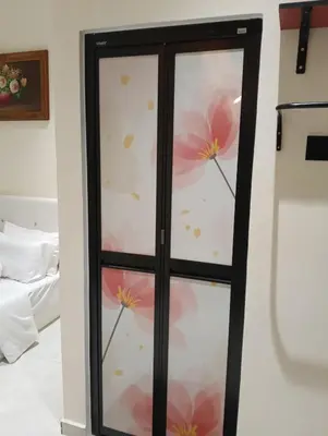 a glass door with pink flowers on it at D'Permata Roomstay Kampung Pelet in Kubang Semang