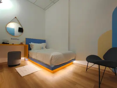 a bedroom with a bed and a mirror and a chair at TREASURE BOX At Heritage Georgetown in George Town