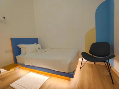 a bedroom with a bed and a chair in it at TREASURE BOX At Heritage Georgetown in George Town