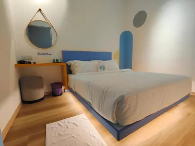 a bedroom with a bed with a blue headboard and a mirror at TREASURE BOX At Heritage Georgetown in George Town