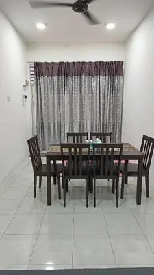 a dining room with a table and chairs and a window at Homestay Kak Rose 2 Kuala Lipis in Kampong Temperah