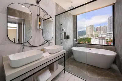 a bathroom with two sinks and a tub and a mirror at Fifth Avenue Hotel in George Town