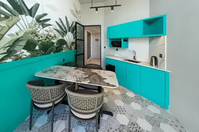 a kitchen with blue cabinets and a table and chairs at Fifth Avenue Hotel in George Town