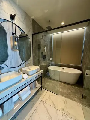 a bathroom with a tub and a sink and a bath tub at Fifth Avenue Hotel in George Town