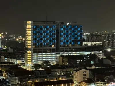 a tall building with blue lights on it at night at Fifth Avenue Hotel in George Town