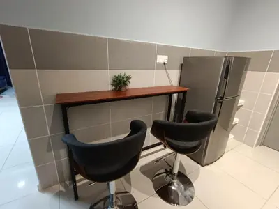 a kitchen with a counter and two chairs and a refrigerator at Homestay D'sasz Meru Ipoh in Ipoh