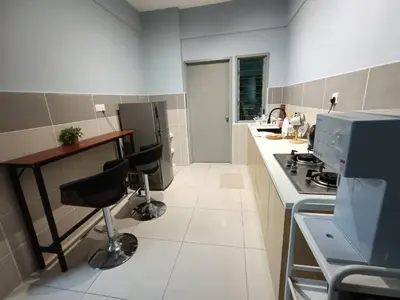 a kitchen with a stove and a counter with stools at Homestay D'sasz Meru Ipoh in Ipoh